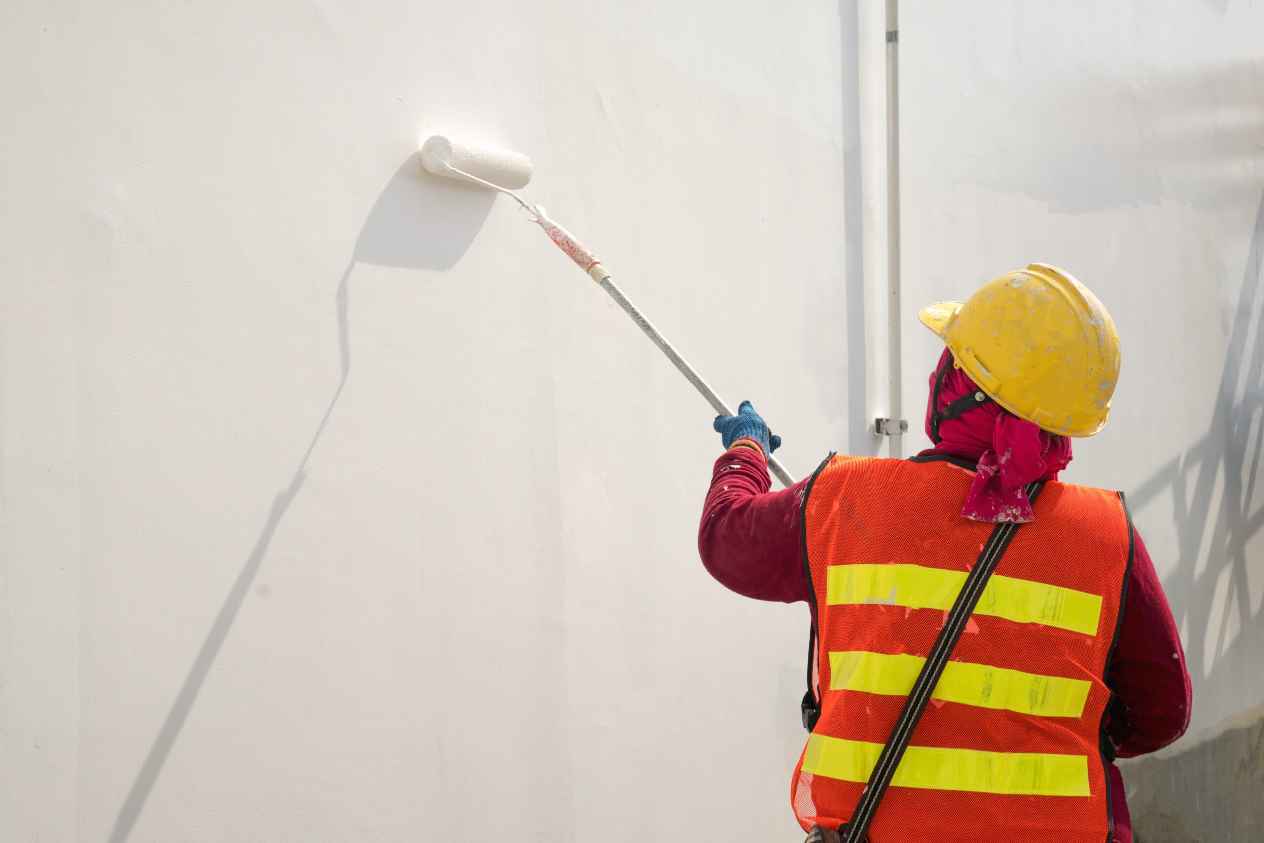 Home construction worker painting a wall